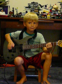 From Norwich to New Orleans - young boy sitting down with guitar in hand